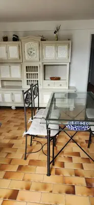 a glass table and two chairs in a room at Charmant T3 en rez de jardin d'une villa in Ghisonaccia