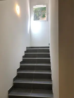 a stairway with black steps and a window at Casa campa lumba in Propriano