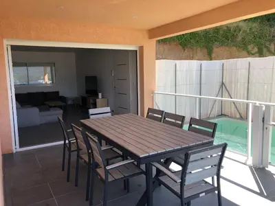 a wooden table and chairs on a balcony at Casa campa lumba in Propriano