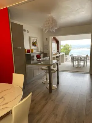 a kitchen with a table and a dining room at Belle villa vue mer piscine parking plage à pied in Porto-Vecchio