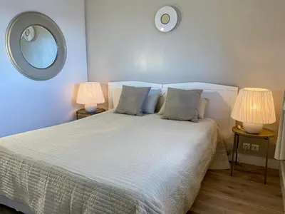 a bedroom with a white bed with two lamps at Belle villa vue mer piscine parking plage à pied in Porto-Vecchio