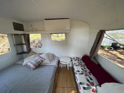 a small room with a bed and a table at Caravane amy on the beach in Lucciana