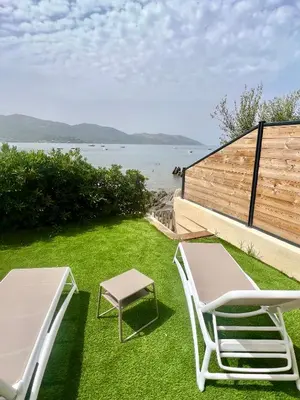 a lawn with two chairs and a table and a bench at Appartement 2-4 pers, ACCES DIRECT MER in Casaglione