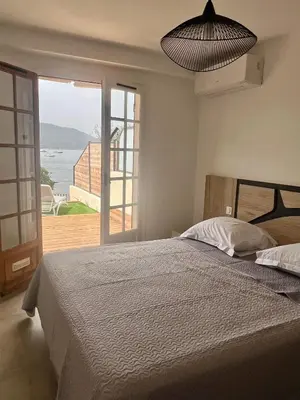 a bedroom with a bed with a view of the ocean at Appartement 2-4 pers, ACCES DIRECT MER in Casaglione