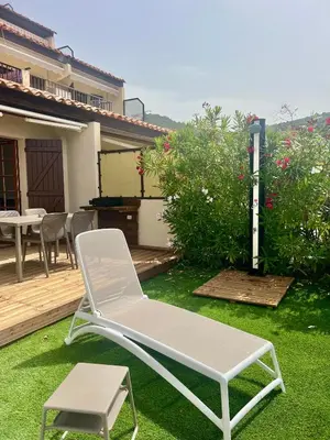 a white lounge chair and a stool on a yard at Appartement 2-4 pers, ACCES DIRECT MER in Casaglione