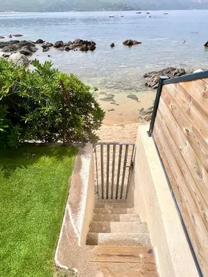 a staircase leading down to the beach with the ocean at Appartement 2-4 pers, ACCES DIRECT MER in Casaglione