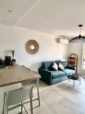 a living room with a blue couch and a table at Appartement 2-4 pers, ACCES DIRECT MER in Casaglione