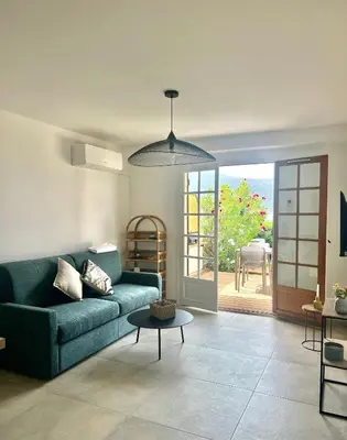 a living room with a blue couch and a table at Appartement 2-4 pers, ACCES DIRECT MER in Casaglione