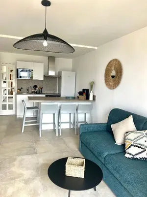 a living room with a blue couch and a kitchen at Appartement 2-4 pers, ACCES DIRECT MER in Casaglione