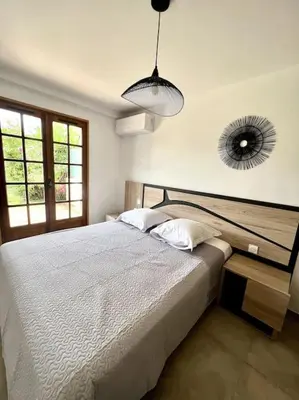 a bedroom with a bed and a mirror on the wall at Accès mer, appartement 2-4 pers sur plage in Casaglione