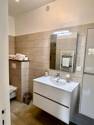 a bathroom with a sink and a mirror at Accès mer, appartement 2-4 pers sur plage in Casaglione