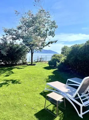 two lawn chairs and a table and a tree at Accès mer, appartement 2-4 pers sur plage in Casaglione