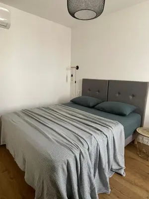 a bedroom with a large bed with blue pillows at Appartement F3 Corte, centre ville in Corte