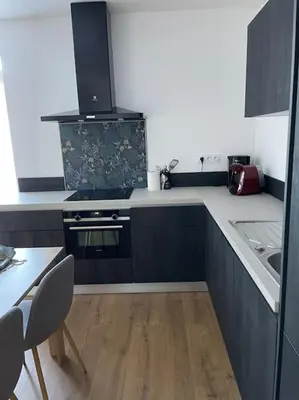 a kitchen with blue cabinets and a stove top oven at Appartement F3 Corte, centre ville in Corte