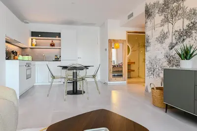 a living room with a table and a kitchen at T2 LUXE Pieds dans l'eau Porticcio in Grosseto-Prugna