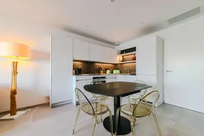 a kitchen with a table and chairs in a room at T2 LUXE Pieds dans l'eau Porticcio in Grosseto-Prugna