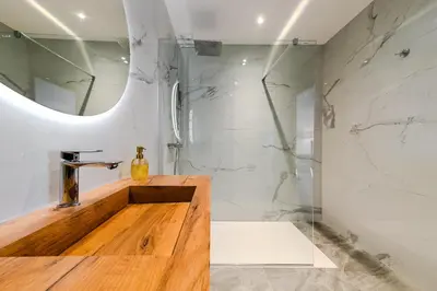 a bathroom with a sink and a shower with a mirror at T2 LUXE Pieds dans l'eau Porticcio in Grosseto-Prugna