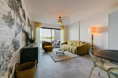 a living room with a couch and a table at T2 LUXE Pieds dans l'eau Porticcio in Grosseto-Prugna