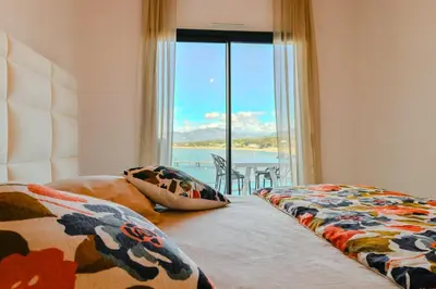 a bedroom with two beds and a view of the ocean at T2 LUXE Pieds dans l'eau Porticcio in Grosseto-Prugna