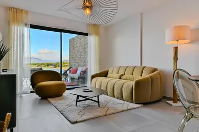 a living room with a couch and a table at T2 LUXE Pieds dans l'eau Porticcio in Grosseto-Prugna