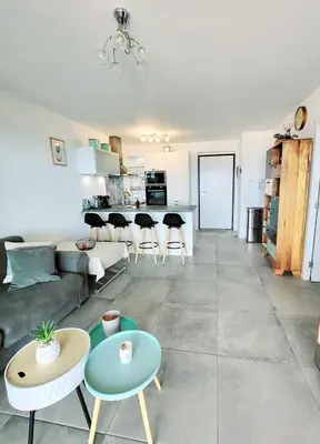 a living room with a couch and a table at Appartement de standing bord de mer in Pietrosella