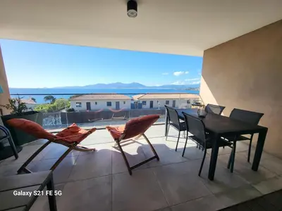 a balcony with a table and chairs and a view at Appartement de standing bord de mer in Pietrosella