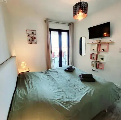 a bedroom with a large green bed with a window at Appartement de standing bord de mer in Pietrosella