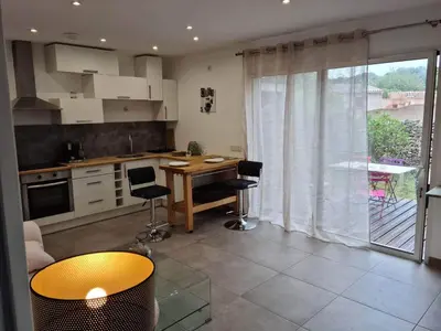 a kitchen with a table and chairs in a room at La Détente in Bonifacio