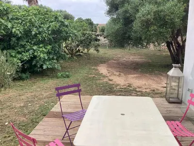 a table and chairs on a wooden deck with a table and chairs at La Détente in Bonifacio