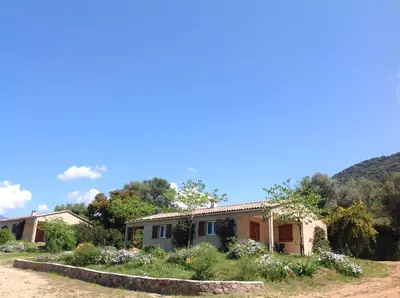 a house with flowers in front of it at Residence Cucunacciu in Cargèse
