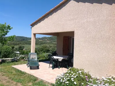 a patio of a house with a table and chairs at Residence Cucunacciu in Cargèse