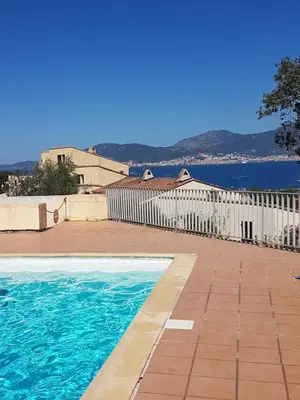 a swimming pool with a white fence and the water at Porticcio avec Piscine proche plage in Porticcio