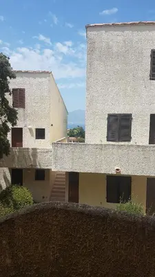 an outside view of a building with a fence at Porticcio avec Piscine proche plage in Porticcio