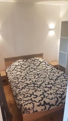 a bed with a black and white comforter in a room at Porticcio avec Piscine proche plage in Porticcio