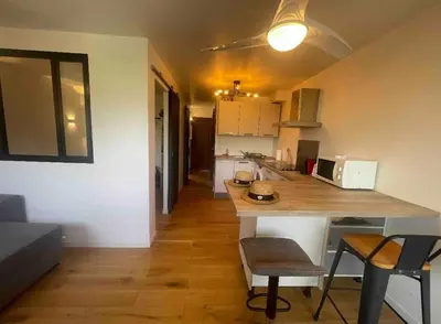 a kitchen with a table and chairs in a room at Porticcio avec Piscine proche plage in Porticcio