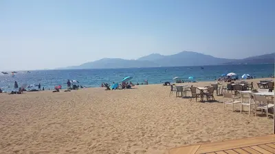 a group of people on a beach with chairs and tables at Porticcio avec Piscine proche plage in Porticcio
