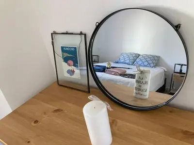 a mirror on top of a wooden table with a bed at F2 Type LOFT à Ajaccio in Ajaccio