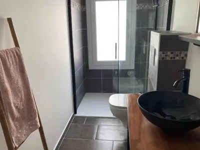 a bathroom with a toilet and a glass shower at F2 Type LOFT à Ajaccio in Ajaccio