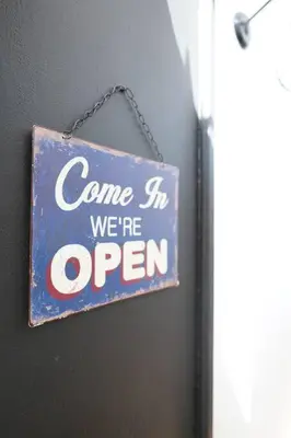 a sign that says come in we are open at F2 Type LOFT à Ajaccio in Ajaccio