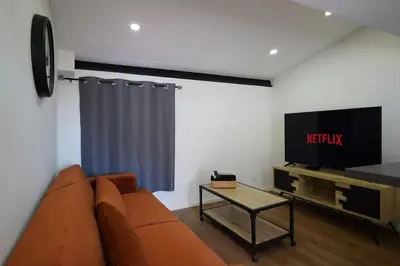 a living room with a couch and a tv at F2 Type LOFT à Ajaccio in Ajaccio