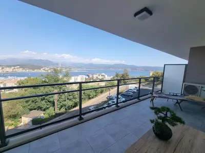 a large balcony with a view of the water at Appartement terrasse spacieuse, vue mer & clim in Ajaccio