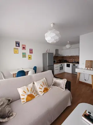 a living room with a couch and a kitchen at Appartement terrasse spacieuse, vue mer & clim in Ajaccio