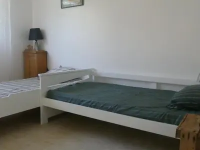 a bedroom with two beds and a night stand at Le Rocher Des Sanguinaires in Ajaccio