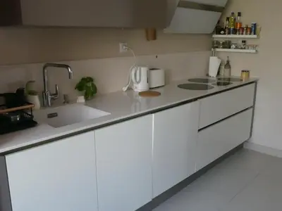 a kitchen with white cabinets and a sink at Le Rocher Des Sanguinaires in Ajaccio