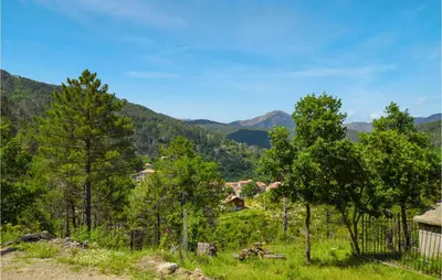 a group of trees in a field with mountains in the background at 1 Bedroom Amazing Apartment In Ghisoni in Ghisoni