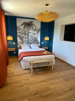 a bedroom with a large bed and a chandelier at La poudrière in Figari