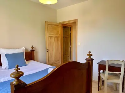 a bedroom with a bed and a table and a chair at *.* Haut de villa U Nespulu di Anghjulina *.* in Borgo