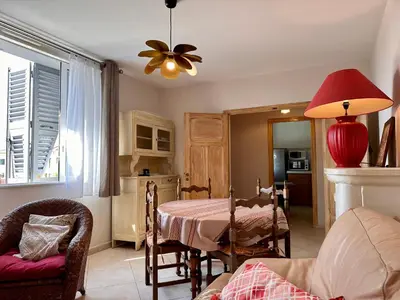 a living room with a table and a ceiling fan at *.* Haut de villa U Nespulu di Anghjulina *.* in Borgo