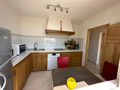 a small kitchen with a table and a microwave at *.* Haut de villa U Nespulu di Anghjulina *.* in Borgo