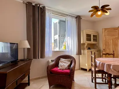 a living room with a chair and a tv and a window at *.* Haut de villa U Nespulu di Anghjulina *.* in Borgo